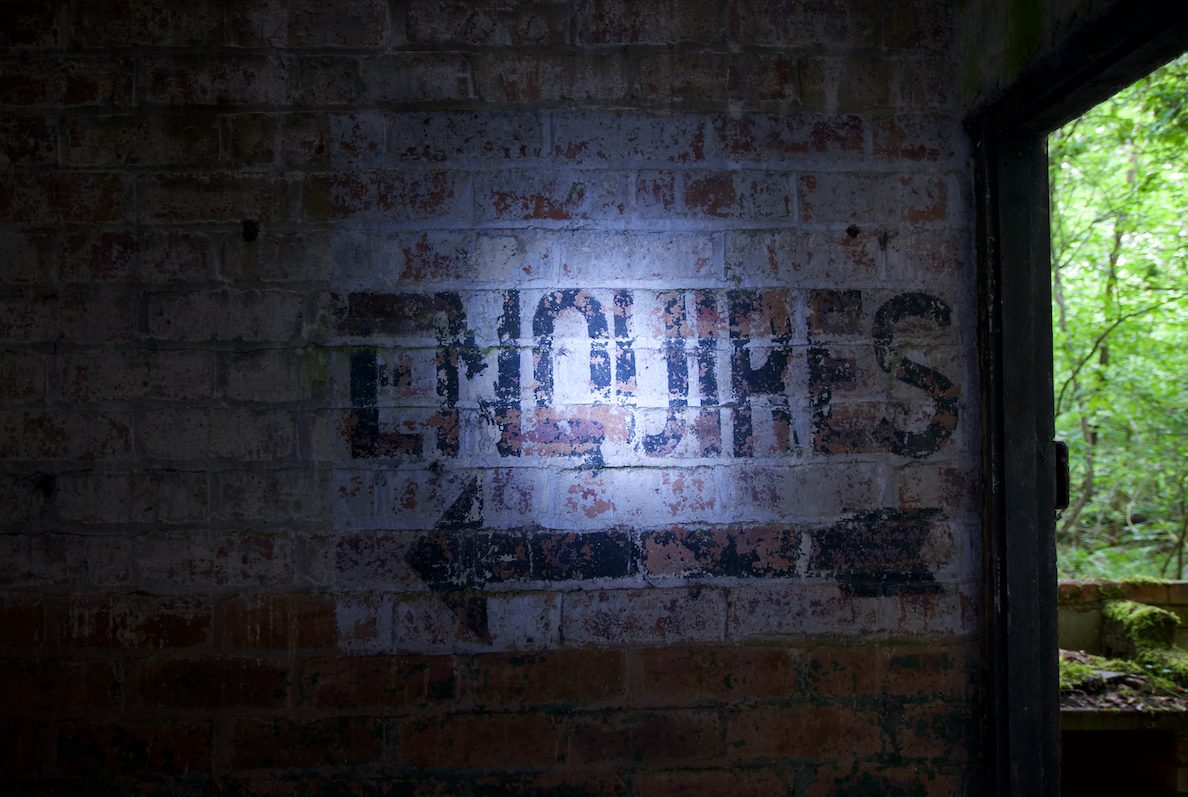 Faded enquiries sign in a derelict building.