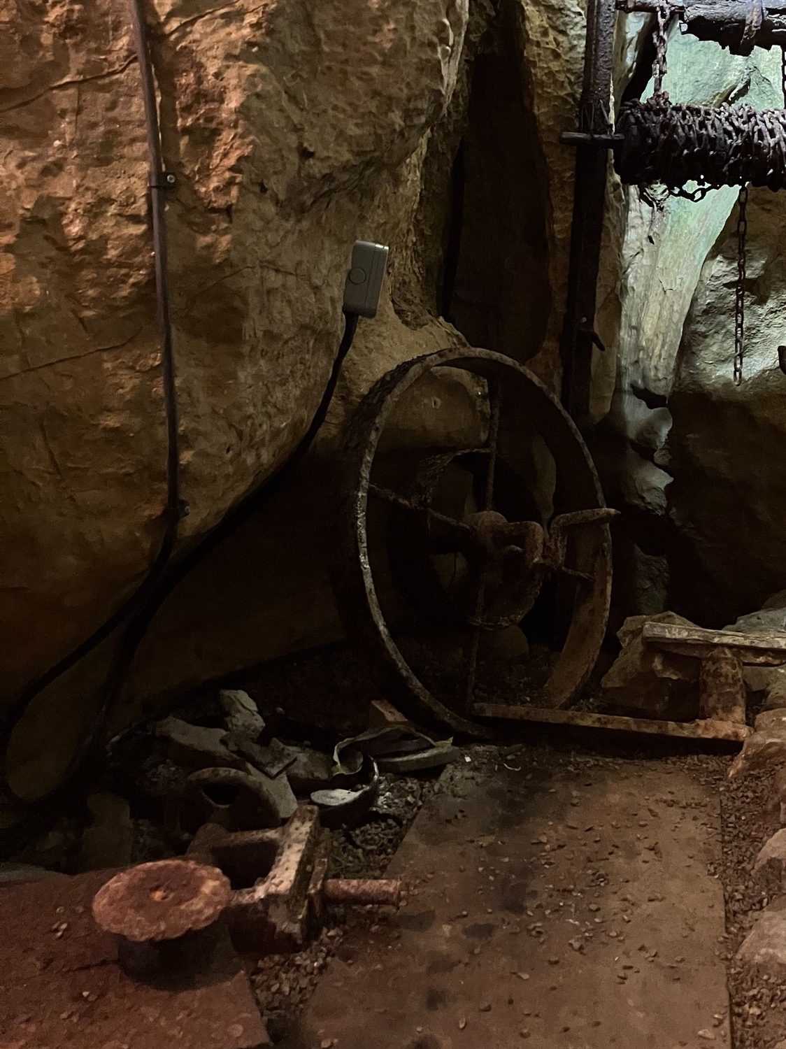 Old rusted mining equipment inside a cave.