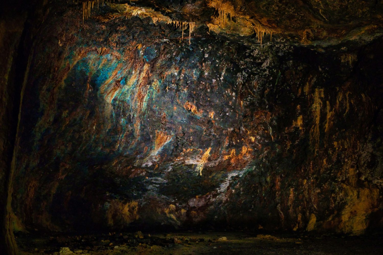 Colourful mineral deposits on a cave wall.