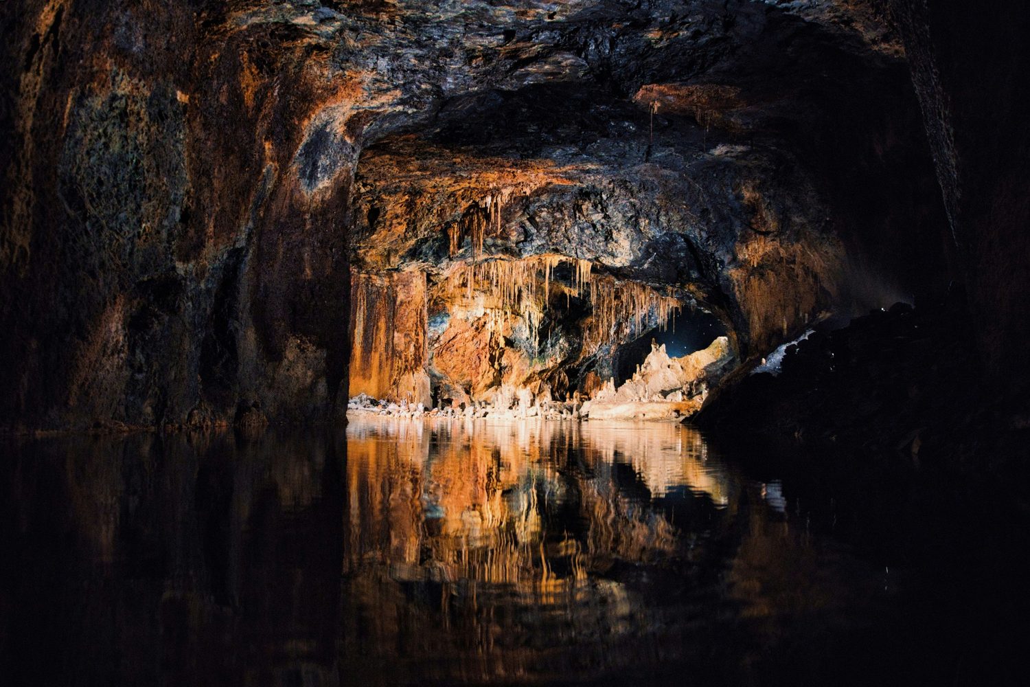 Cave chamber reflected in dark water.